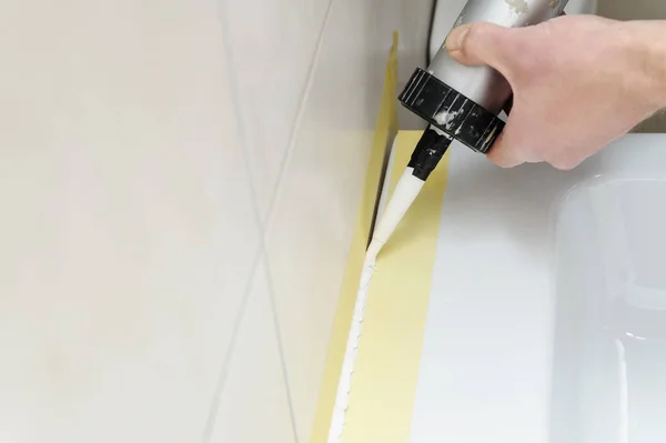 Bir adam silikon dolgu macunu giyiyor.