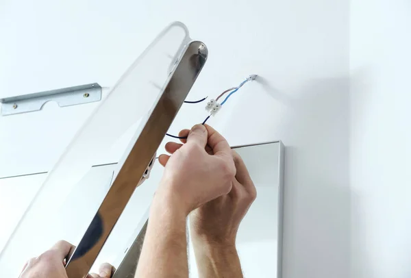 Installazione della lampada sopra lo specchio . — Foto Stock