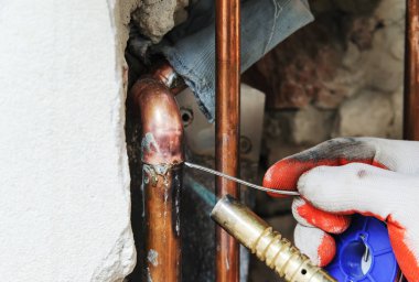 Bir işçi Gaz yakıcı ve lehim bakır boru lehimleme için kullanıyor.