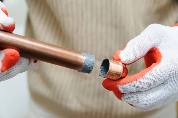 Een werknemer is het verbinden van koperen buizen. — Stockfoto