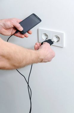 A man is charging the smartphon. clipart