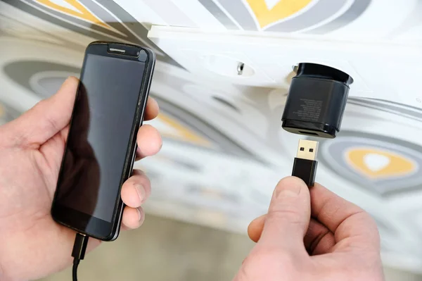 Un hombre está cargando el smarphon . —  Fotos de Stock