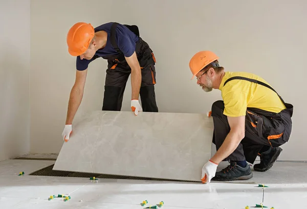 Instalando uma grande telha cerâmica . — Fotografia de Stock