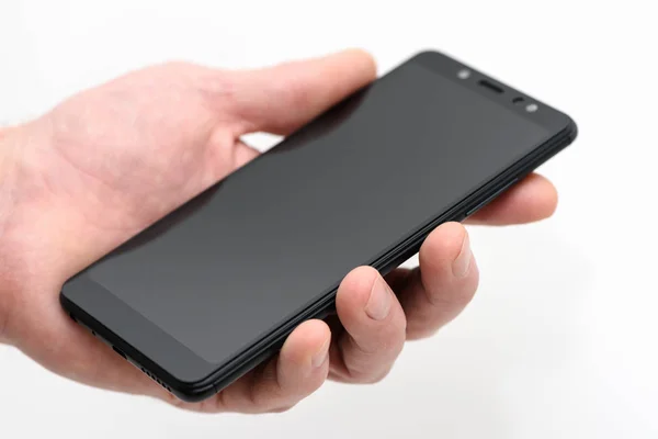 Smartphone negro en la mano . — Foto de Stock