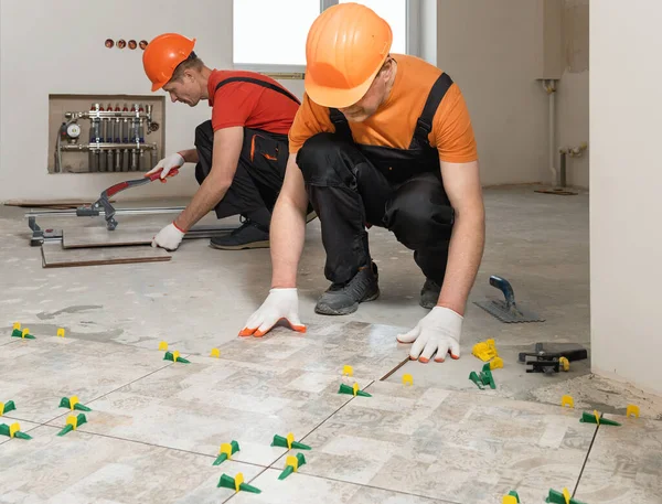 Zwei Arbeiter Verlegen Keramikfliesen Auf Dem Boden — Stockfoto