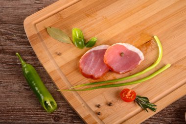 Füme sığır filetosu parça dinlenirken ahşap bir gemide, dilimlenmiş taze sebze yanında yatıyordu