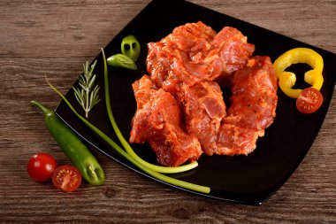 domuz eti, ham şişleri sebze yanındaki siyah plaka üzerinde yalan