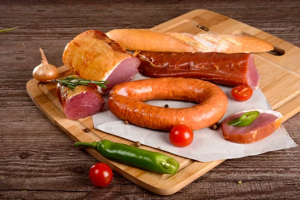 Salchicha de carne de pechuga con especias en una tabla de madera verduras —  Fotos de Stock