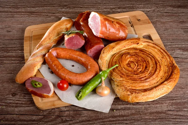 Salchicha de carne de pechuga con especias en una tabla de madera verduras — Foto de Stock