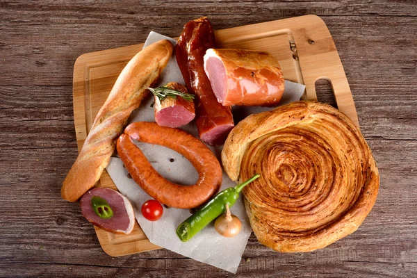 Salchicha de carne de pechuga con especias en una tabla de madera verduras — Foto de Stock