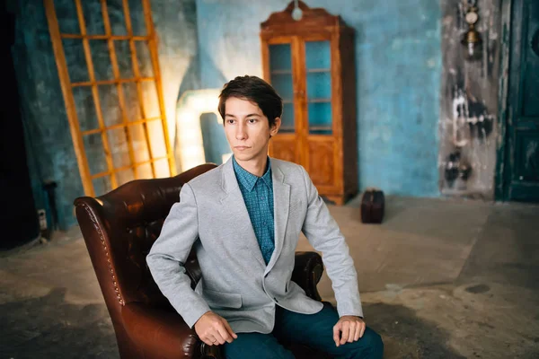 Portréja egy jóképű férfi kabát szürke és kék nadrág — Stock Fotó
