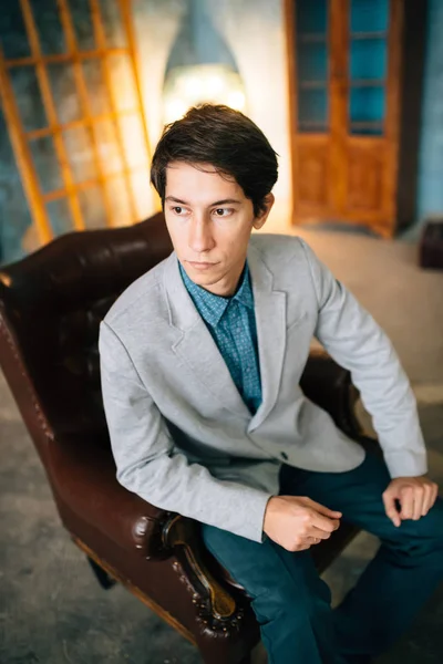 Retrato de un hombre guapo con chaqueta gris y pantalones azules — Foto de Stock