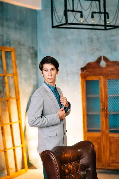 Retrato de un hombre guapo con chaqueta gris y pantalones azules — Foto de Stock