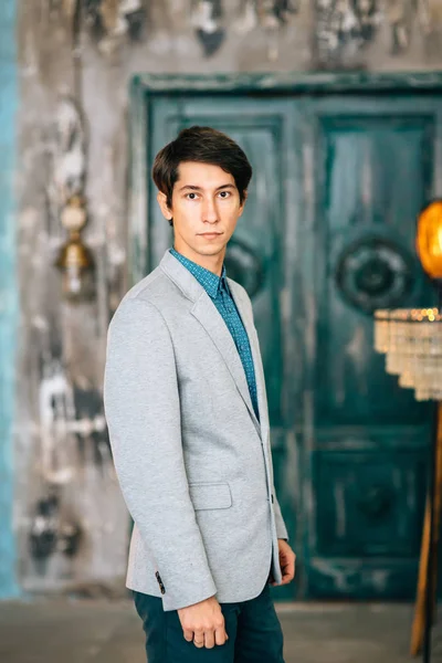Joven hombre guapo en una elegante chaqueta gris — Foto de Stock