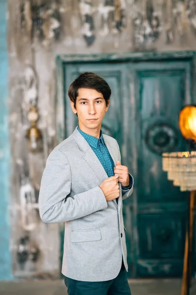 Joven hombre guapo en una elegante chaqueta gris — Foto de Stock