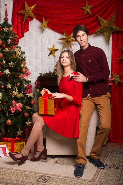 Приваблива молода пара чоловік і жінка святкують Різдво навколо дерева сосна — стокове фото