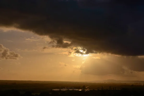 Cumulus sunset clouds with sun setting down — Stock Photo, Image