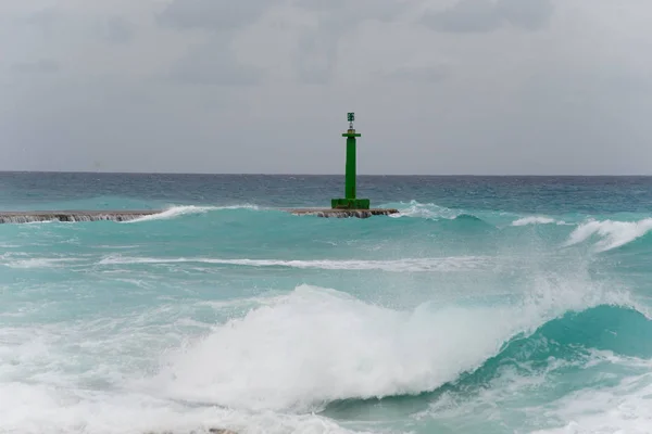 waves crashing on the lighthouse and pier. Cuba
