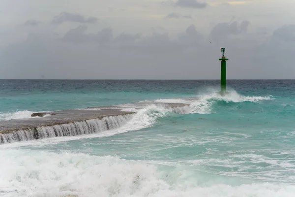 waves crashing on the lighthouse and pier. Cuba