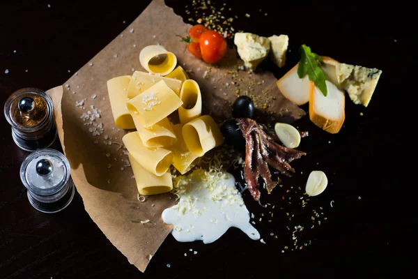 Comida italiana e ingredientes pasta acostada en el papel —  Fotos de Stock