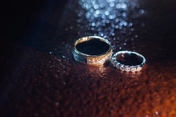 Anillos de boda con gotitas de agua contra — Foto de Stock