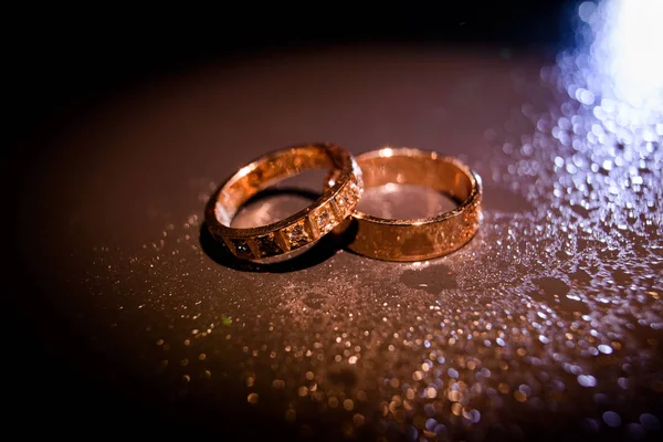 Свадебные кольца с капельками воды против — стоковое фото