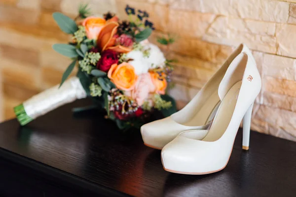 Svatební boty nevěstu na tmavý stůl — Stock fotografie