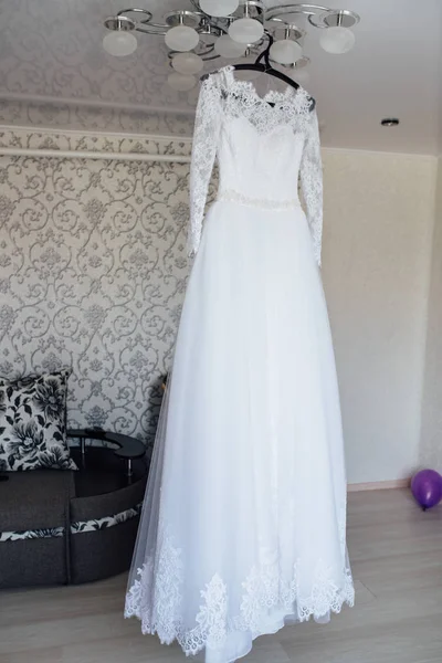 Svatební šaty visí uprostřed místnosti — Stock fotografie