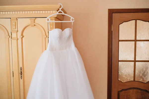 Svatební šaty visí uprostřed místnosti — Stock fotografie