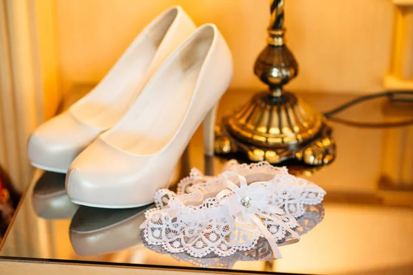 Svatební boty nevěstu na tmavý stůl — Stock fotografie