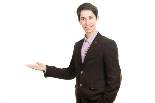 Bello giovane uomo d'affari in giacca e cravatta sorridente guardando la macchina fotografica che tiene un palmo in alto — Foto Stock