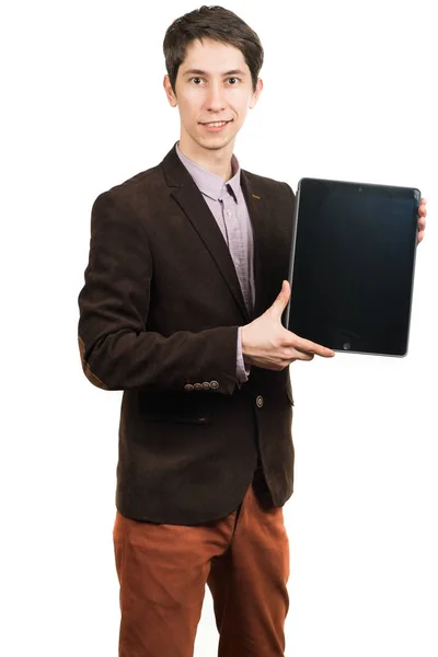 Wesoły, młody biznesmen w garnitur działa na tablecie cyfrowych i uśmiechając się stojąc na białym tle — Zdjęcie stockowe