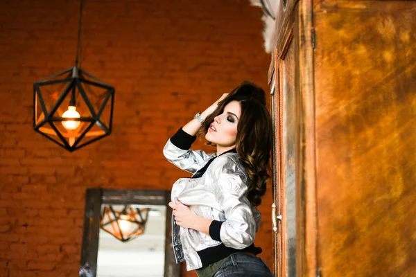 Girl posing in a silver jacket. The Studio photos. r — Stock Photo, Image