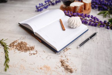 Bir takvim ve bir fincan kahve ile bruschetta, ahşap masaya lupins çiçek servis kalemle Not