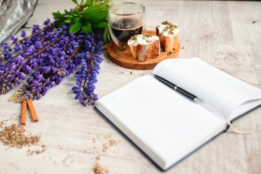 Bir takvim ve bir fincan kahve ile bruschetta, ahşap masaya lupins çiçek servis kalemle Not