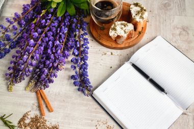 Bir takvim ve bir fincan kahve ile bruschetta, ahşap masaya lupins çiçek servis kalemle Not