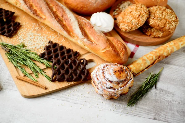 Свежеиспеченный хлеб. Различные виды хлеба и рулонов на борту — стоковое фото