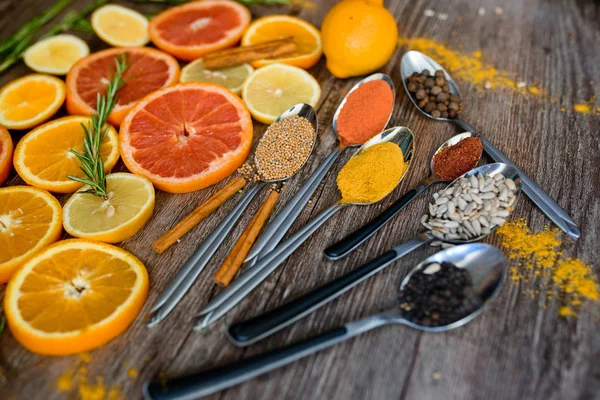 the fragrance of spices, red pepper, black pepper, mustard,sunflower seeds ,and orange slices of citrus fruits on dark wooden background of the table.