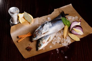 Kırmızı soğan, tuz ve biber ile lezzetli tuzlanmış ringa balığı, buz eski ahşap arka plan üzerine dökülür. Rustik tarzı.