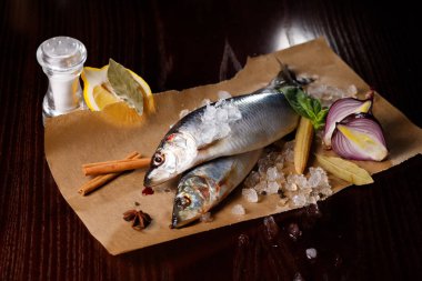 Kırmızı soğan, tuz ve biber ile lezzetli tuzlanmış ringa balığı, buz eski ahşap arka plan üzerine dökülür. Rustik tarzı.