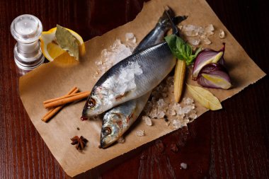 Kırmızı soğan, tuz ve biber ile lezzetli tuzlanmış ringa balığı, buz eski ahşap arka plan üzerine dökülür. Rustik tarzı.