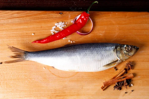 Salted herring with red pepper and cinnamon sticks — Stock Photo, Image