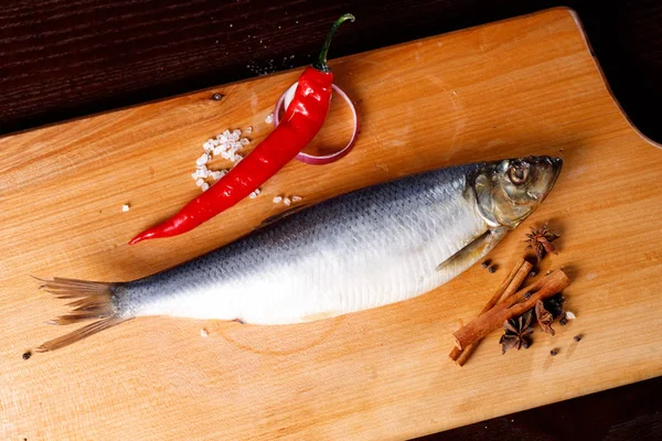 Salted herring with red pepper and cinnamon sticks — Stock Photo, Image