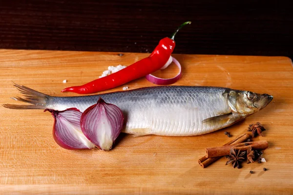 Salted herring with red pepper, onion, cinnamon sticks — Stock Photo, Image