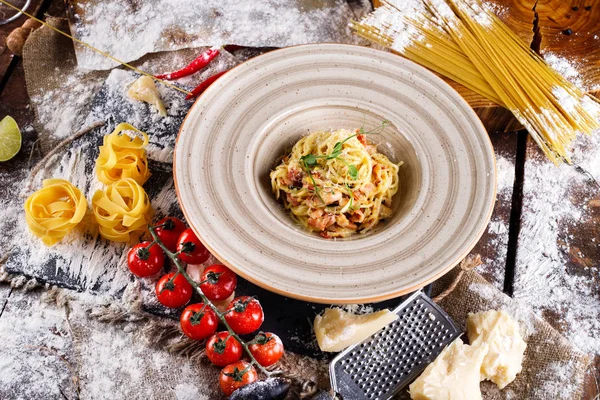 Pâtes Carbonara au parmesan et sauce dans une assiette sur fond de bois — Photo