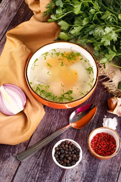 Картина миски традиционного куриного супа, подаваемого в миске на овощном фоне — стоковое фото