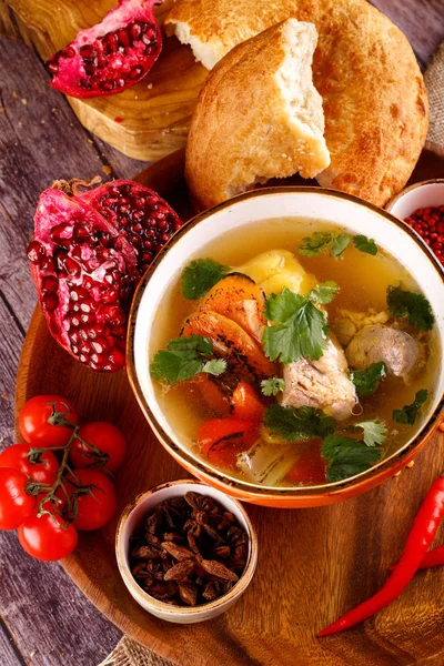 Узбекский суп шурпа в миске с двумя острыми перцами — стоковое фото