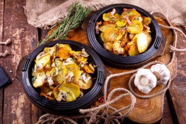 Ahşap bir tahtanın arka planında, et kaplı kızarmış patates.