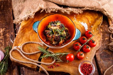 Tahta arka planda sebzelerin yanında peynirli ızgara karnabahar.