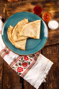 Çocuk krepleri, kahvaltı, krep haftası, hafif ev yapımı krepler, krep hamuru, ahşap arka planda şekersiz krepler.